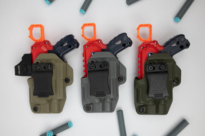Three tactical gun holsters in different colors on a white background