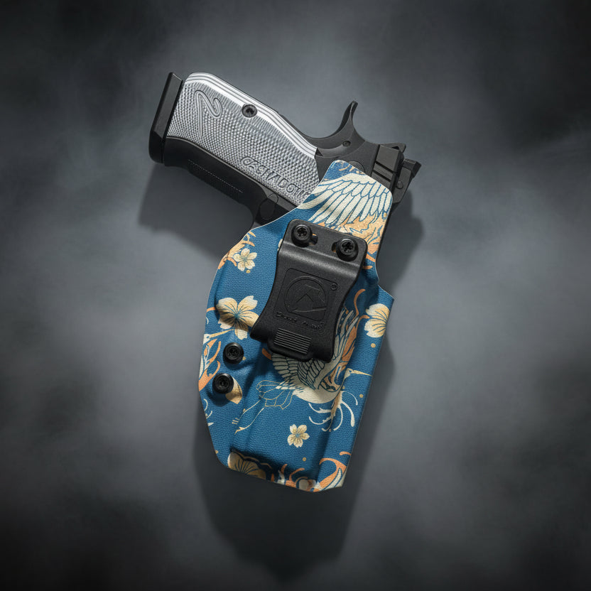 Handgun with a floral-patterned holster on a white background